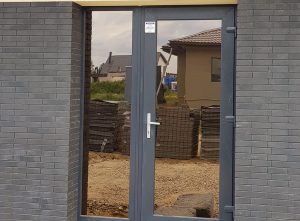 Namo įėjimo durų stiklai apklijuoti bronzine veidrodine plėvele iš išorinės pusės